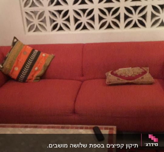 ספה אדומה עם כריות צבעוניות על מושביה